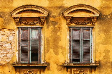 Sarı bina cephesinde ahşap panjurlu eski pencereler, Hırvatistan 'ın eski Crikvenica kentinden ayrıntılar