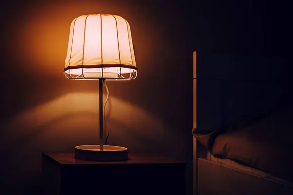 夜の寝室のナイトスタンドのベッドサイドランプ 選択的な焦点 — ストック写真