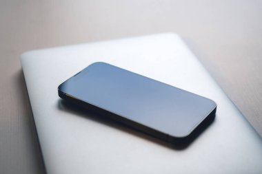 Ofis masasında akıllı telefon ve dizüstü bilgisayar, iş için modern teknoloji ekipmanı, seçici odaklanma