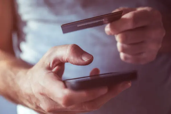 信用卡和手机应用在线购买 男性通过智能手机在互联网上完成财务交易 — 图库照片