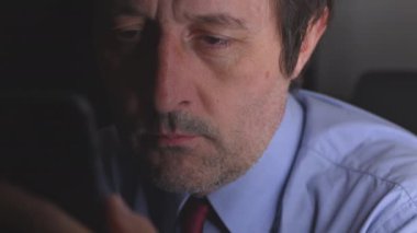 Arabanın arka koltuğunda cep telefonu kullanan bir işadamı gece geç saatte işten eve dönecek, seçici bir odak noktası olacak.