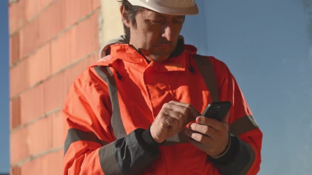 Engenheiro Construção Usando Telefone Inteligente Móvel Local Durante Inspeção Foco — Vídeo de Stock
