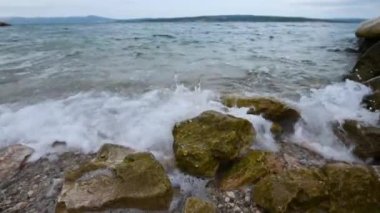Okyanus dalgaları kıyı şeridinde fren yapıyor güneşli yaz gününde onları beyaz deniz köpüğüyle kaplıyor.