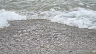 Deniz dalgalarının kıyı şeridinde çarpışmasının yavaş çekim görüntüleri, seçici odak noktası