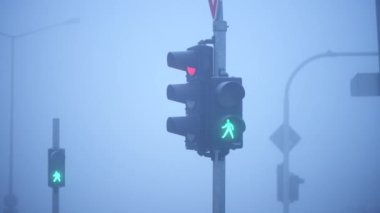 Sisli bir sabahta yeşilden kırmızıya sembolik trafik ışığı, seçici odak