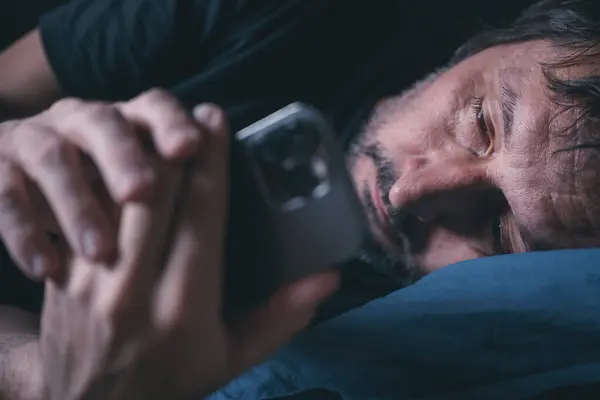 Man Met Behulp Van Smartphone Terwijl Liggen Het Bed Avonds — Stockfoto