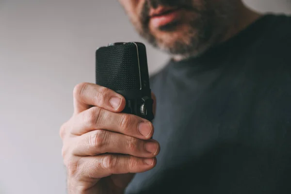 Man holding voice recording device, selective focus