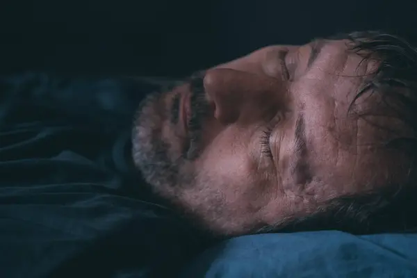 男人睡在床上 紧闭脸蛋 有选择地集中精神 — 图库照片