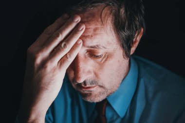 Endişeli aşırı çalışan iş adamı gecenin geç saatlerinde, seçici odaklı gösterişsiz.