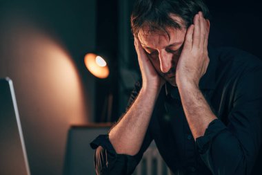 İşyerinde baş ağrısı, ofis masasında ağır baş ağrısıyla oturan yorgun işadamı fazla mesai yaparken, seçici odaklanma