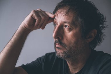 Aşırı Düşünme ve Felç Konsepti, Pencereden gelen ışığa bakan dalgın erkek portresi, seçici odaklanma