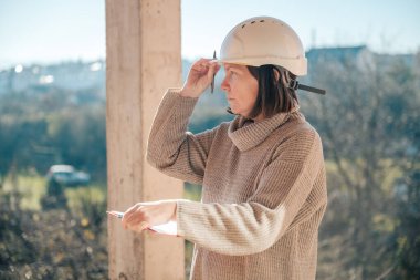 İnşaat teftişi sırasında not alan ve yorum yapan kadın mimar, seçici odaklanma