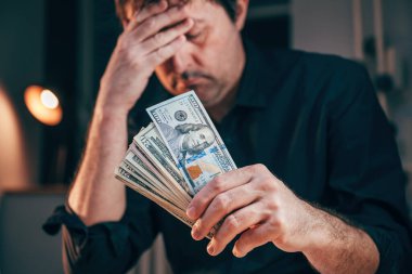 Asgari ücret ve düşük maaş kavramı, Amerikan doları banknotları elinde tutan adam, seçici odaklanma