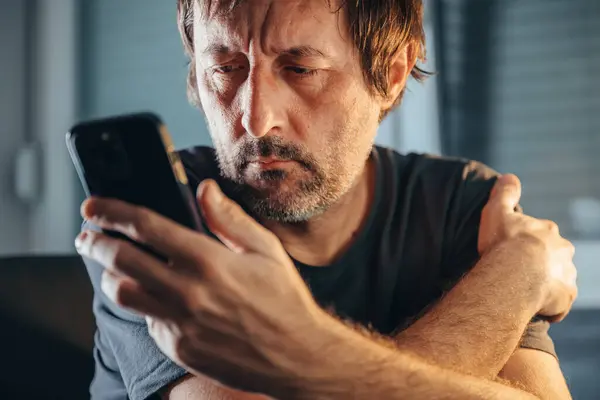 Mężczyzna Czytający Sms Telefonie Komórkowym Niespokojny Mężczyzna Trzymający Komórkę Domu — Zdjęcie stockowe