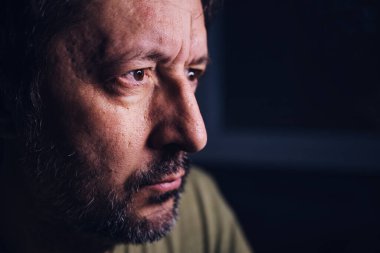 Endişeli adam, yetişkin erkek portresi gece cihaz ekranına bakıyor, televizyonda kötü haberler duyuyor, seçici odaklı sade anahtar.