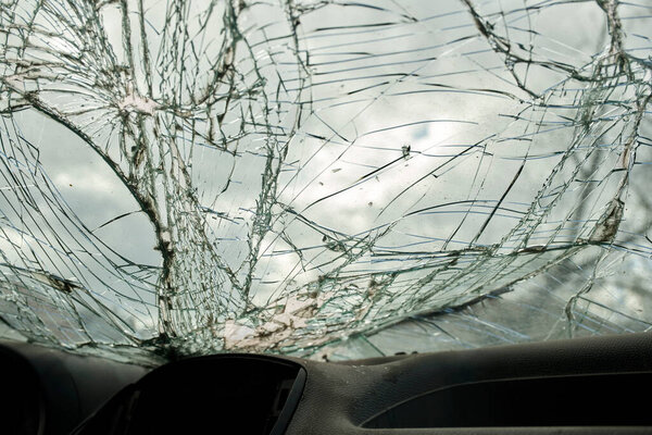 Broken glass texture, car windshield after traffic accident, shattered glass material background, selective focus
