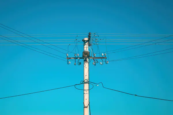 Strommast Mit Oberleitungen Und Straßenlaterne Gegen Blauen Himmel lizenzfreie Stockbilder
