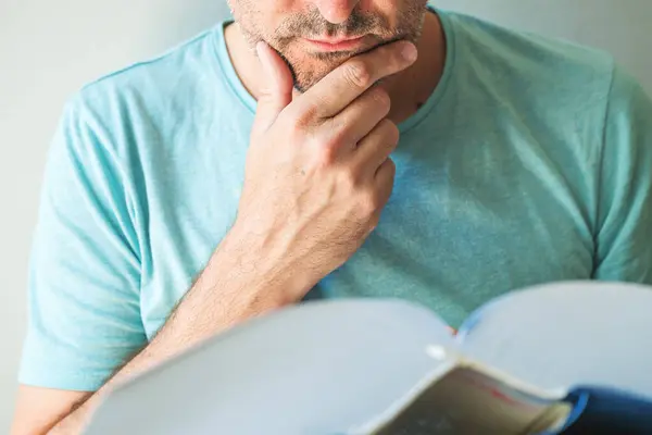Closeup Male Reading Book Stroking Chin Selective Focus Stock Photo