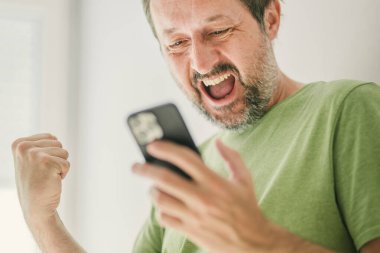 Mutlu adam cep telefonundan tatmin edici bir mesaj aldı, seçici odaklanma