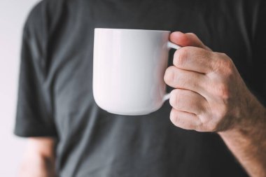 Elinde beyaz kahve fincanı olan adam, seçici odaklanma.