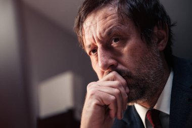 İşadamı yeniden düşünüyor, orta yaşlı erkek girişimcinin portresi çenesinde elle düşünme, seçici odaklanma