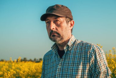 Çiçek açan kanola tarlasında ortaya çıkan alerji yüzünden tahriş olmuş çiftçi, seçici odaklanma