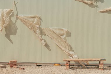 İnşaat alanındaki tuğlalardan ve ahşaptan yapılmış doğaçlama bank, seçici bir odak noktası.