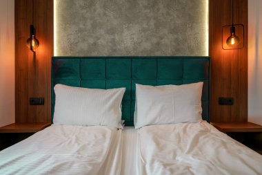 Lüks bir apartmanın içinde, yatak odasındaki beyaz yastıklar seçici bir odak noktası.