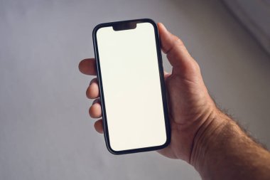 Erkek eli akıllı telefon modeli, yatak odasında cep telefonu kullanan adam. Seçici odak.