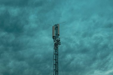 Mobil telefon sinyal yineleyici kule bulutlu gökyüzüne karşı, seçici odaklanma