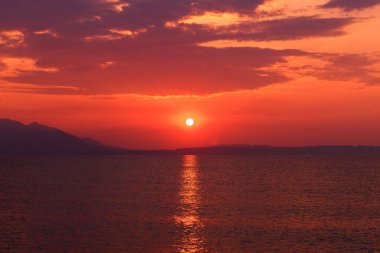 Beautiful scenic sunrise at Strymonian gulf of Aegean sea in summer morning, selective focus clipart