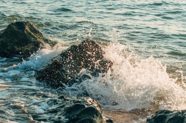 Ocean wave splash, high speed photography capturing sea water and foam crushing at the rock on a shoreline, selective focus clipart