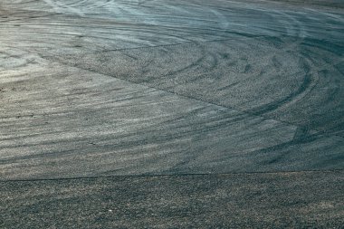Asfalt yolda lastik izleri yanmış, seçici odak noktası