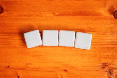 Tahta masadaki dört boş beyaz küp kopya alanı, seçici odak