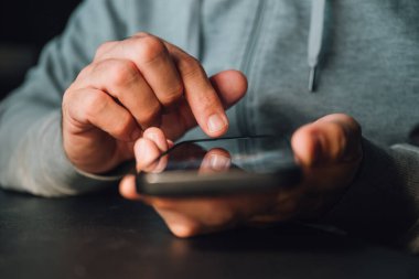 Kıyamet kayışı ya da kıyamet sörfü konsepti, akıllı telefon kullanarak erkek ellerine yakın çekim, seçici odaklanma