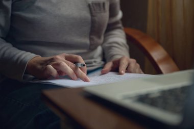 Female freelancer doing paperwork in home office interior, selective focus clipart