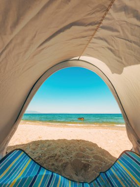 View of the horizon over ocean water from sun tent on the beach, selective focus clipart