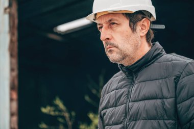 İnşaat mühendisi, yıkım alanında beyaz koruyucu miğferli, seçici odaklı.