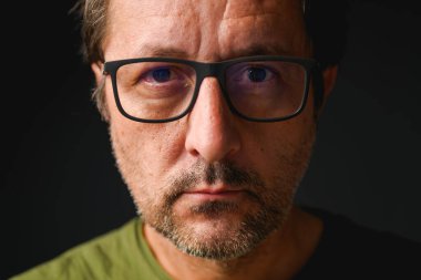 Yetişkin beyaz adamın gözlük taktığı vesikalık fotoğraf, seçici odaklı sade anahtar.
