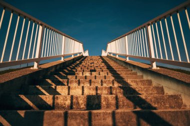 Metalik parmaklıklı beton merdiven, seçici odaklı düşük açılı görüş.