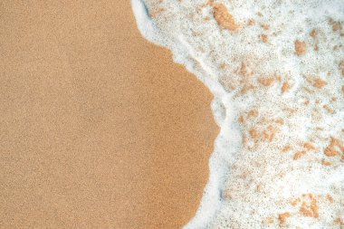 Deniz kenarındaki kumsal ve deniz köpüğü, üst manzara.