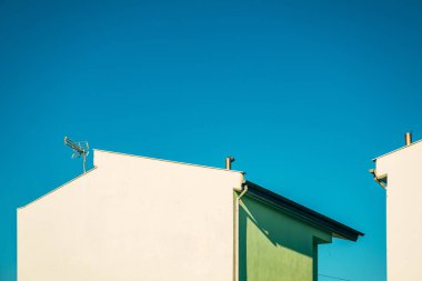 Evler ve mavi gökyüzü, Yunanistan 'da beyaz ve yeşil duvarlı binaların minimalist kompozisyonu, kopyalama alanı dahil