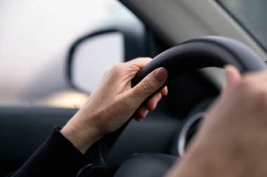 Otomobil direksiyonundaki kadın ellerinin yakın çekimi, seçici odaklanma