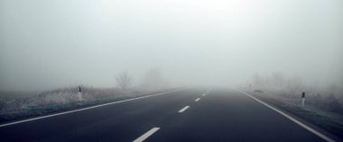 Sisli kış sabahında boş kırsal yol, seçici odak