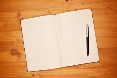 Ofis masasında bir defter, boş beyaz sayfalı bir günlük, metin modeli, üst görünüm