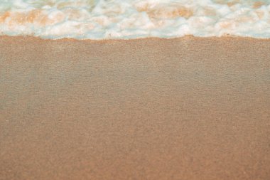 Yumuşak ıslak kumsal kumu ve deniz köpüğü, Ege kıyılarındaki kumlu kumlu yüzey dokusu. Seçici odak.