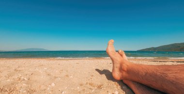 Kumsalda dinlenmek, erkek ayağına yakın durmak, seçici odaklanma.