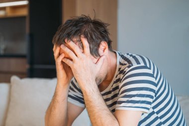 Evde üzgün, hayal kırıklığına uğramış bir adam, zihinsel sağlık ve depresyon konsepti, seçici odaklanma