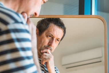 Aynanın önündeki endişeli adam, seçici odaklanma.