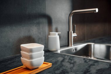 Mutfak tezgahı, servis kapları, musluk ve lavabo, seçici odaklanma.